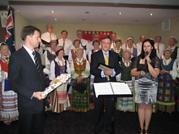 Priekyje iš kairės: LR ambasadorius Japonijai, Australijai ir Naujajai Zelandijai Dainius Kamaitis, ALB Sydnėjaus Apylinkės Valdybos nariai Vytautas Juška ir Greta Savickaitė-Fletcher. Už jų - Sydnėjaus lietuvių choras „Daina“. „MP“ nuotr.